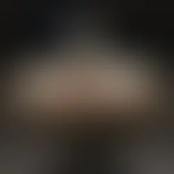 A jeweled French crown on display, featuring gold, diamonds, emeralds, and intricate detailing with a cross on top, photographed under museum lighting.