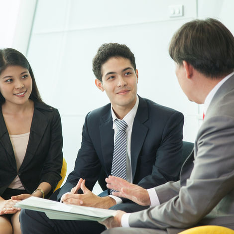 Stock photo 2 men and a woman talking in a office setting