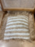 Coussin rayé tressé beige et blanc sur chaise