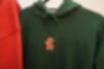 gingerbread man waving embroidered onto a green pullover hoodie