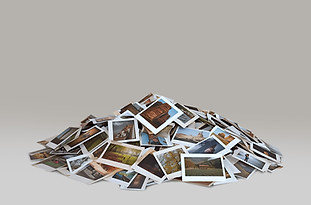 Product photography of a huge pile of photos illustrating the deluxe photo package with full coverage service.