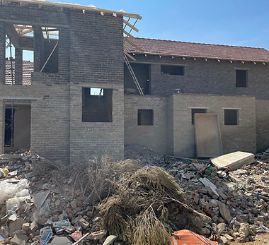 full house building with debris around it