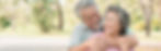 An elderly asian couple embraces while standing outdoors