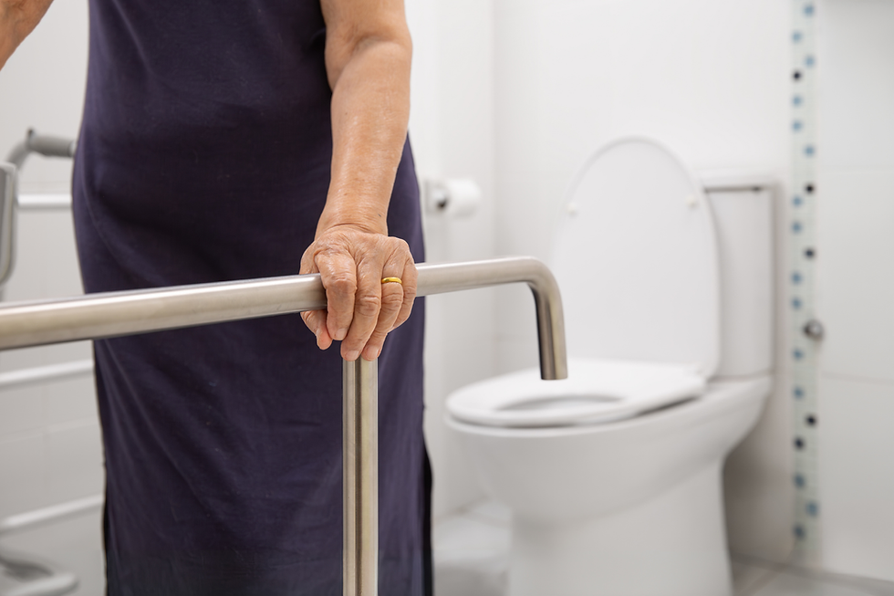older adult using grab bar near toilet