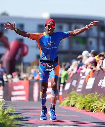 Coach Marques Garcia celebrating at a triathlon finish line