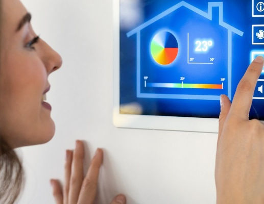 Shot of pretty young woman using the home automation system on digital tablet to regulate 