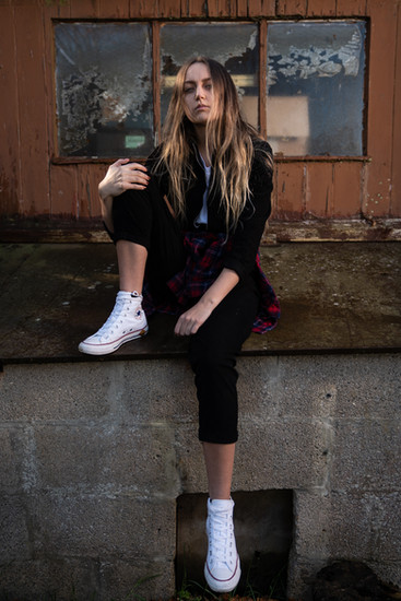 Girl Sitting on Garage Roof In black Overalls And White Converse.Inspired By Billy Joel, Uptown Girl.