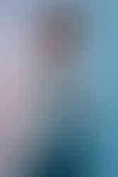 Woman Holding White Leather Jacket Over Her Shoulder In Blue and Red Studio Lights. Inspired by David Bowie, Legacy.