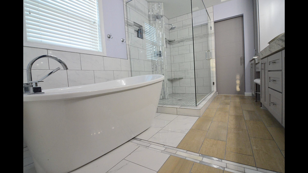 Modern master bathroom with freestanding tub on the left, glass shower in center, vanity on right