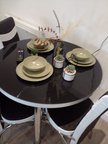 A small table with crockery and flower vase kept in an orderly manner