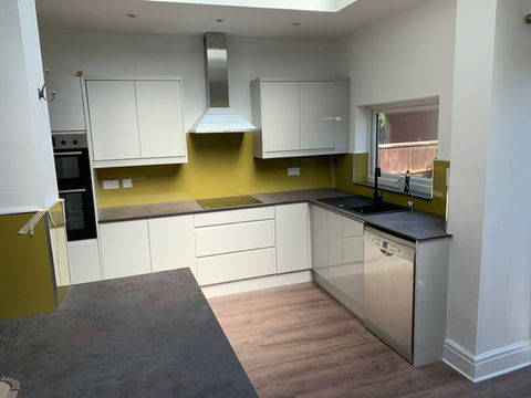 A kitchen with white cabinets and yellow accents