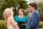 Wedding officiant laughing with bride and groom during a fun ceremony
