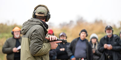 Instructor demonstrating pistol shooting techniques to a class