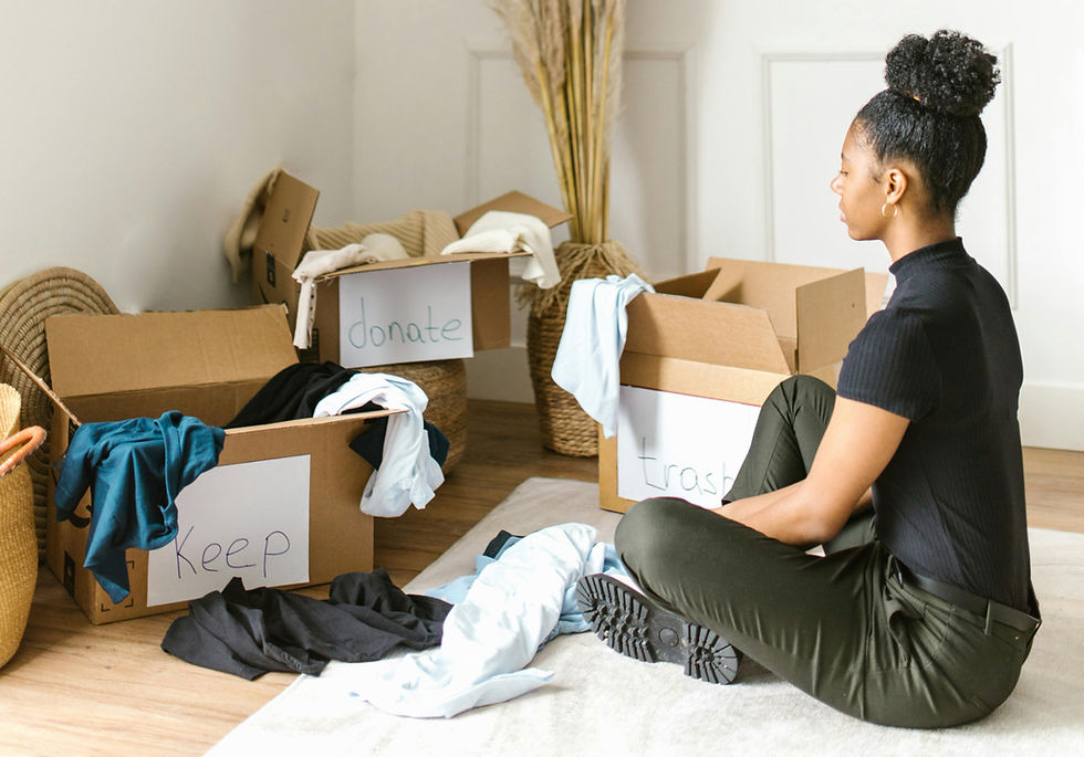 Eine Frau sortiert beim Frühjahrsputz Kleidung in Kisten