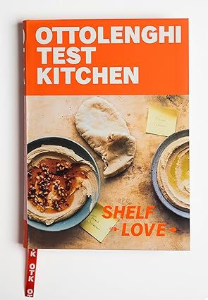 Cookbook cover titled "Ottolenghi Test Kitchen: Shelf Love" featuring dishes with hummus and bread.