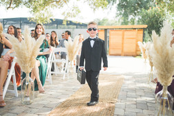 Ring bearer walking down the aisle with his shades
