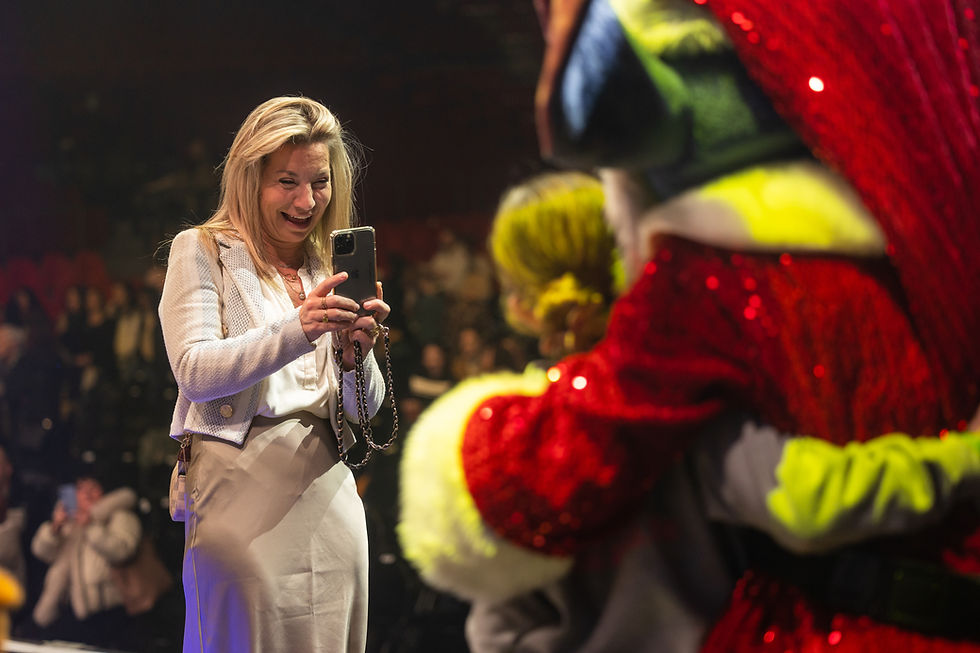 Maman qui prend en photo son enfant avec un personnage du spectacle le pays des chansons