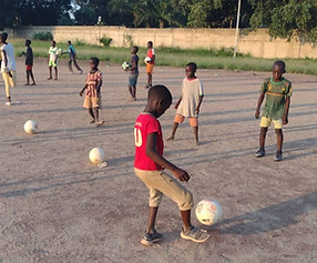 Children in Tanzania playing soccer together through iAct program