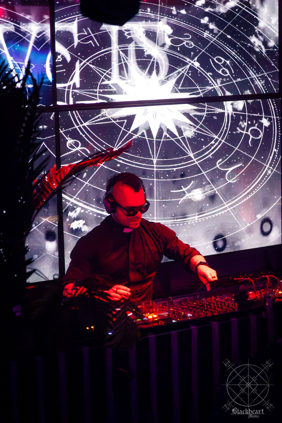Audio Freq in his priest collar at the decks beneath projected star charts