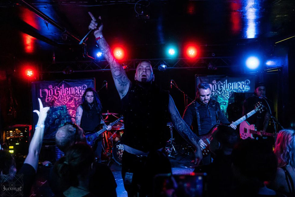 Full band on stage with hands raised in the crowd