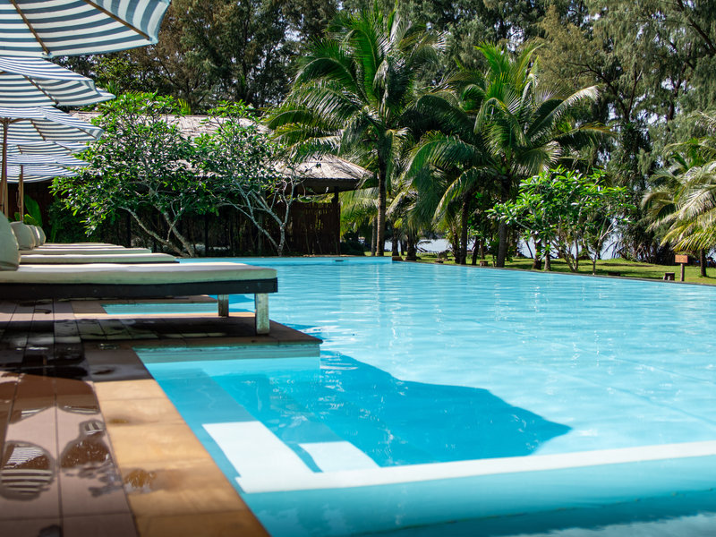 Beachfront pool with loungers and parasols