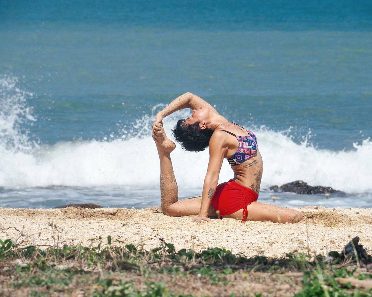 Yoga pose on the beach with waves