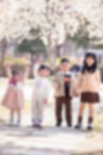 Four children under cherry blossoms by snapinkorea