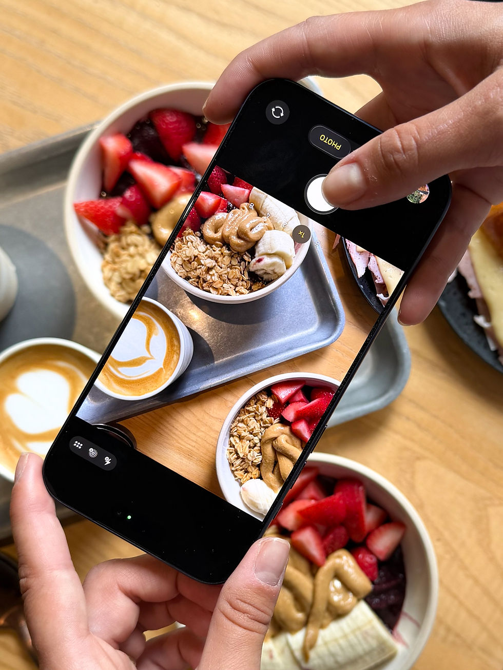 Taking a phone photo of acai bowls and lattes