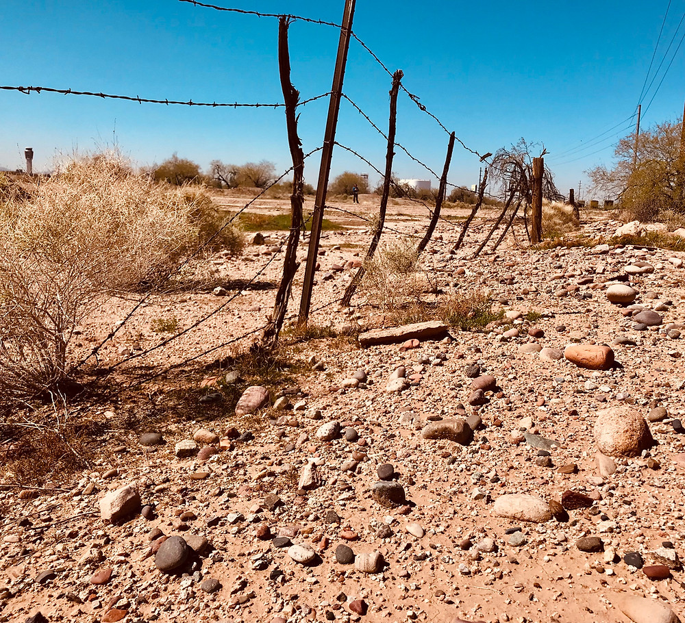 Image of dry rocky landscape with barbed wire fence