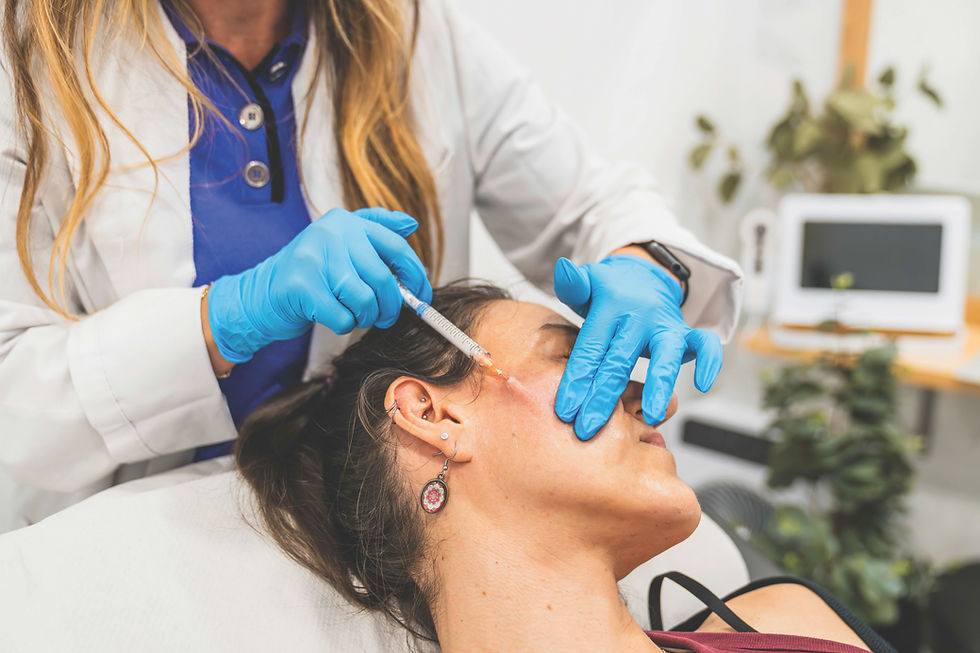 A person receives a cosmetic injection in the cheek from a professional wearing blue gloves in a medical setting.