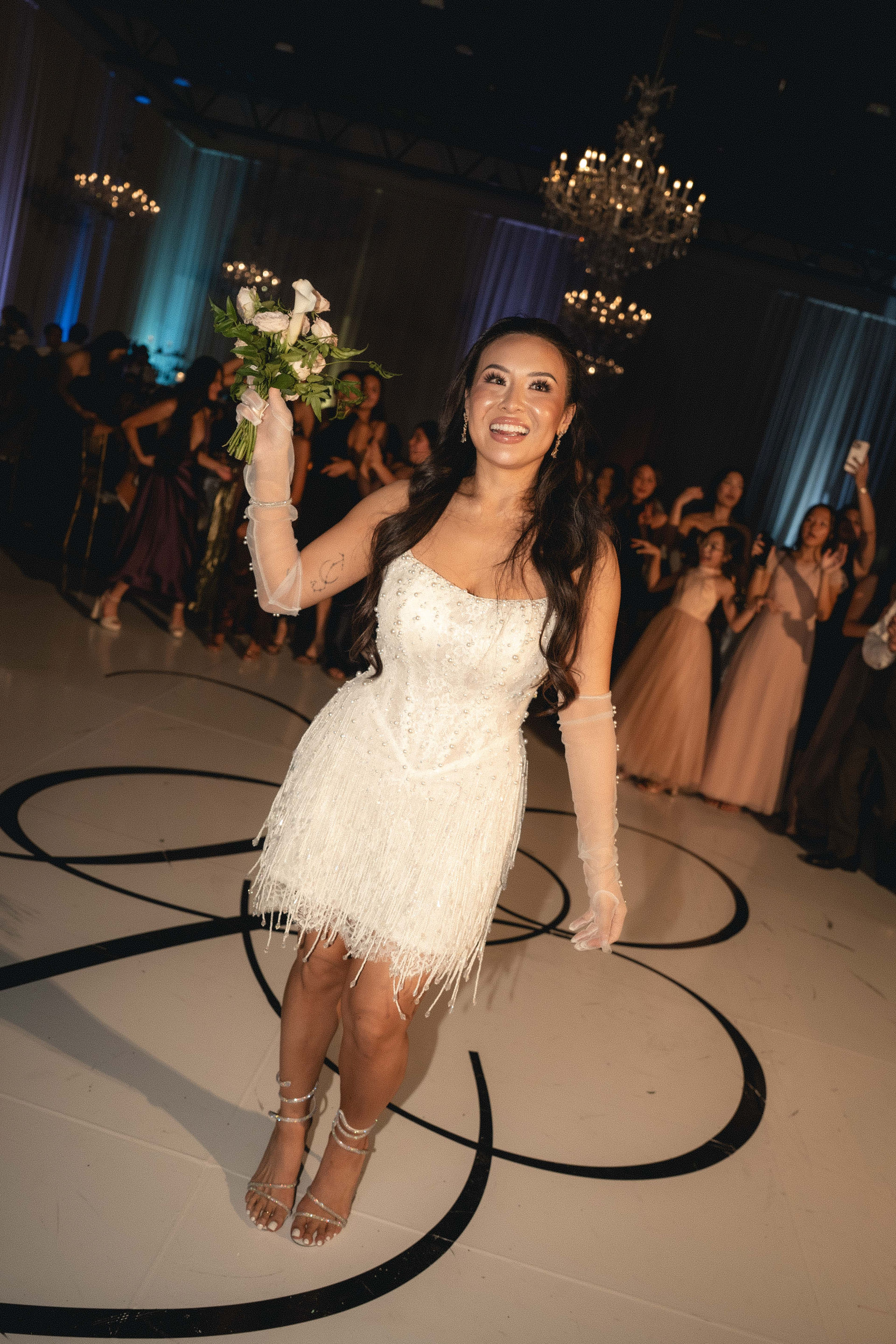 Bride in her reception dress tossing the bouquet