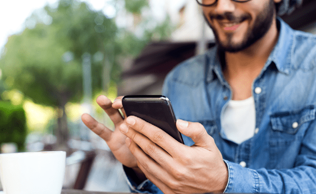 Muchacho con un Teléfono Móvil en la Mano
