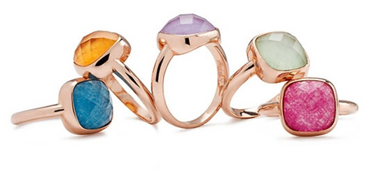 A collection of five rings made by Bronzallure. Each has a colourful stone set in a rose gold setting.