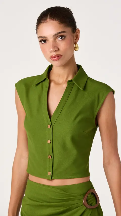 Woman wearing a green sleeveless button-up collared top