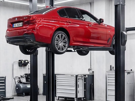 Red car on a hydraulic lift in a modern garage