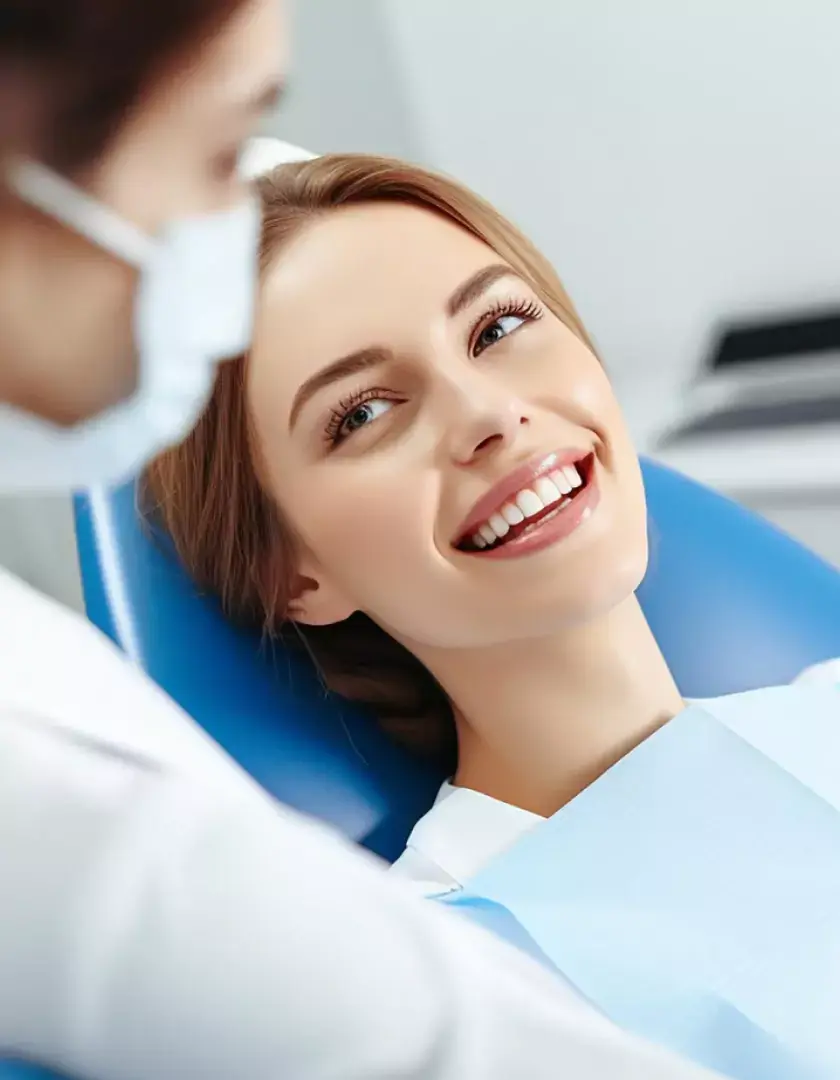 Smiling woman in dentist chair during a dental checkup in a clinic.
