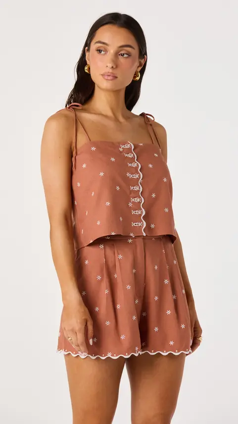 Woman wearing a terracotta polka dot crop top and shorts
