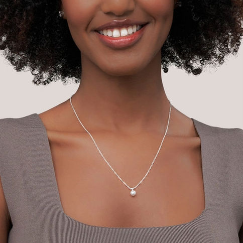Woman wearing delicate silver ball necklace