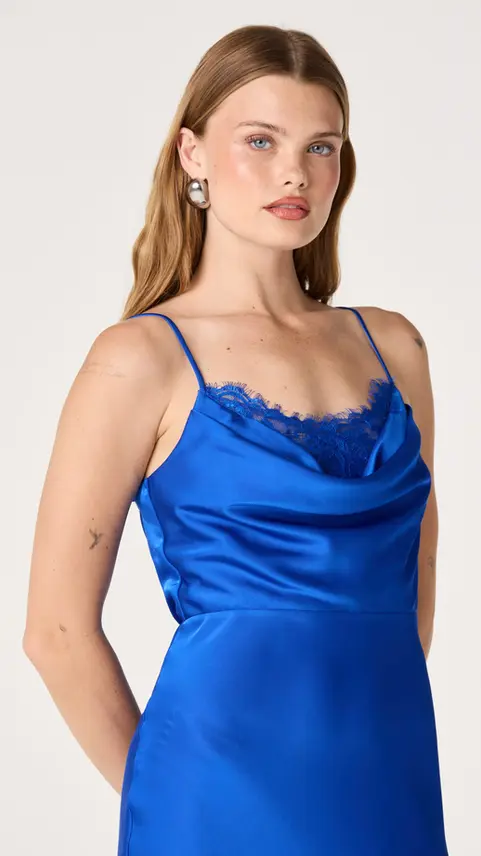 Woman wearing a blue satin camisole with lace trim.