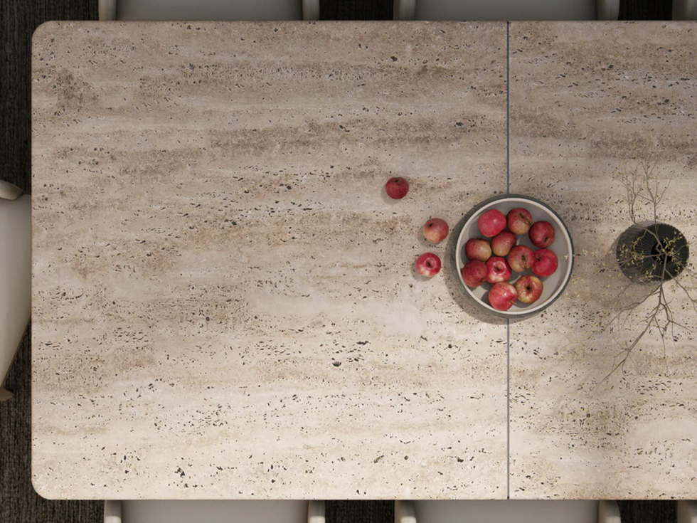 Overhead view of a dining table, apples in a bowl, and surrounding chairs.