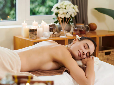 Woman relaxing during a spa massage with candles and flowers