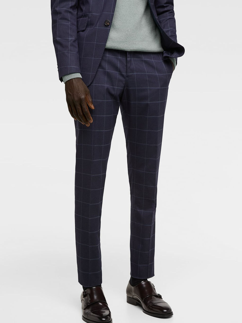 Man wearing a dark navy blue tuxedo suit with a checkered pattern and brown leather shoes