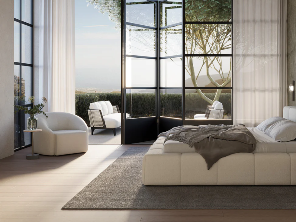 Modern bedroom interior with open doors, white bed, chair, and couch.