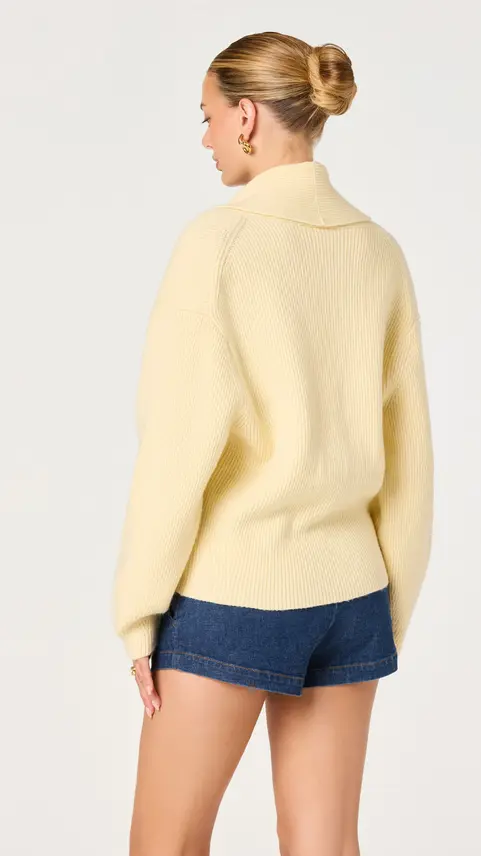 Back view of a cream collarless tailored blazer.