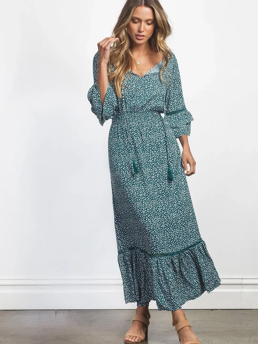 Woman wearing floral print dress with ruffled hem and sleeves. Charme