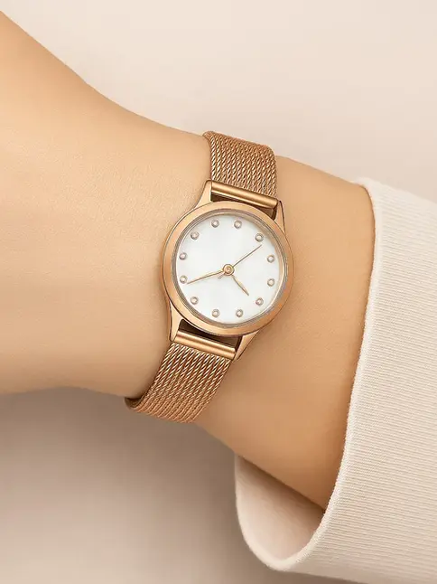 Vintage-inspired watch with rose gold mesh band on wrist