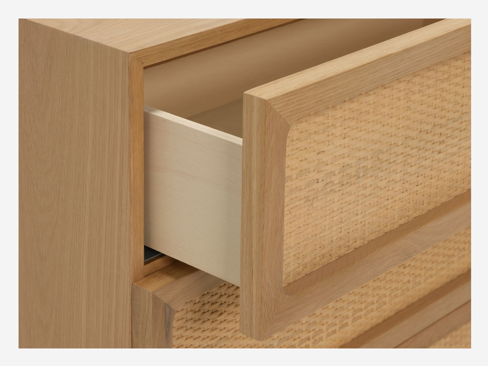 Open drawer of light wood dresser with woven detail