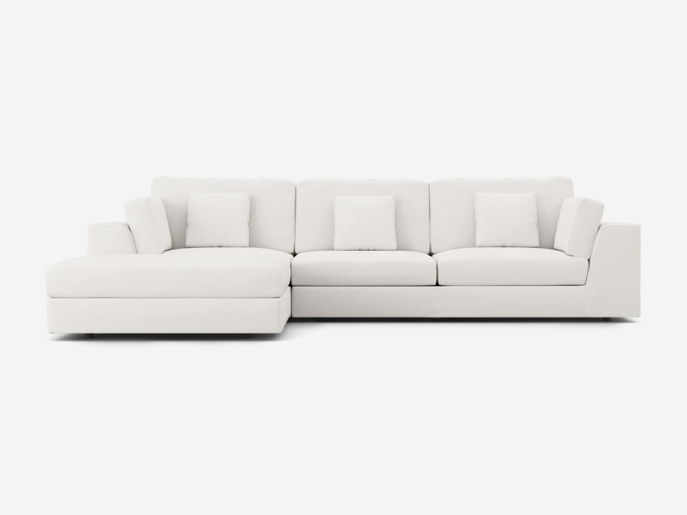 White sectional sofa with multiple pillows, comfortable living room furniture.