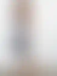 Woman wearing striped dress, tie front, standing on a reflective surface. Charme