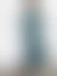 Woman wearing a green floral dress with frills and a matching Charme.